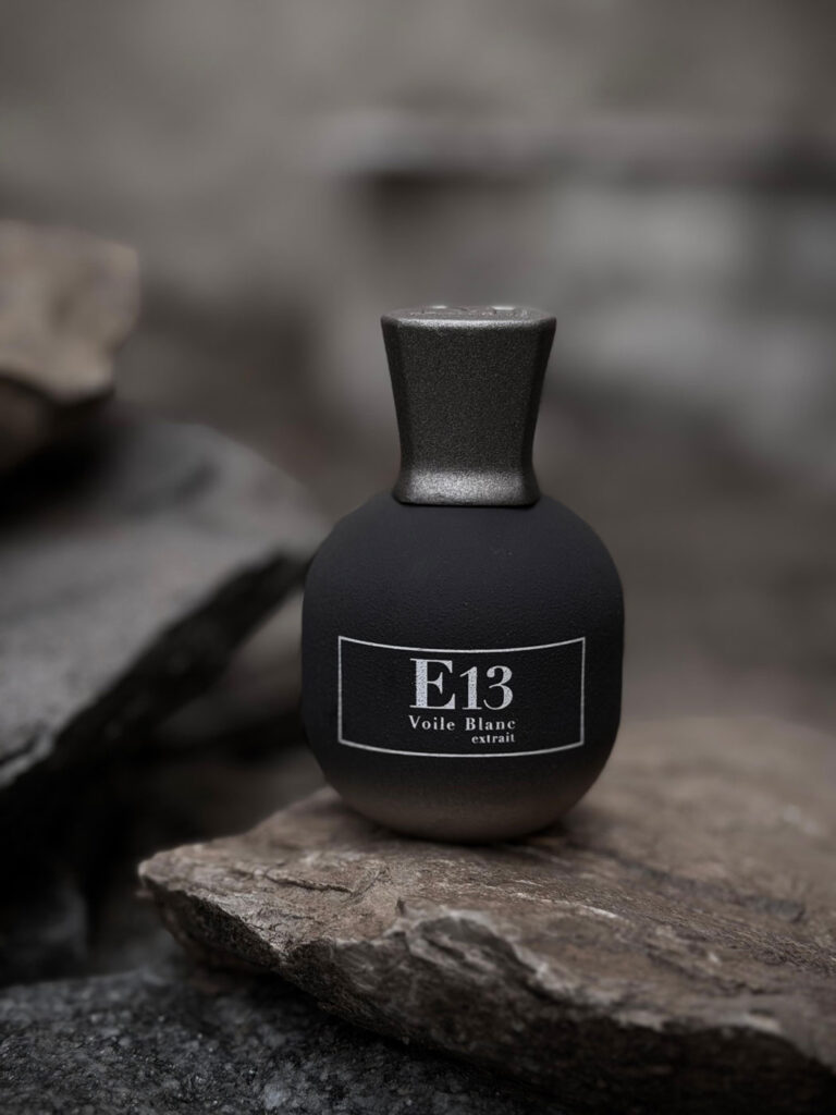 Michele Marin Essenza E13 Voile Blanc extrait de parfum – boccetta nera opaca con tappo argento su sfondo di roccia naturale